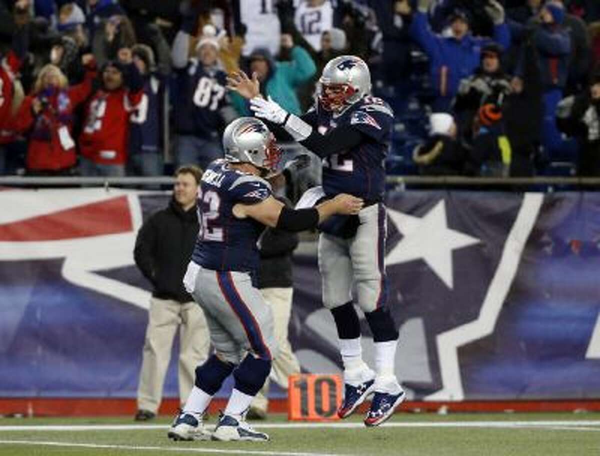 Tom Brady celebrates his go-ahead touchdown pass with center Ryan Wendell (62) in the fourth quarter of a game against the Browns.