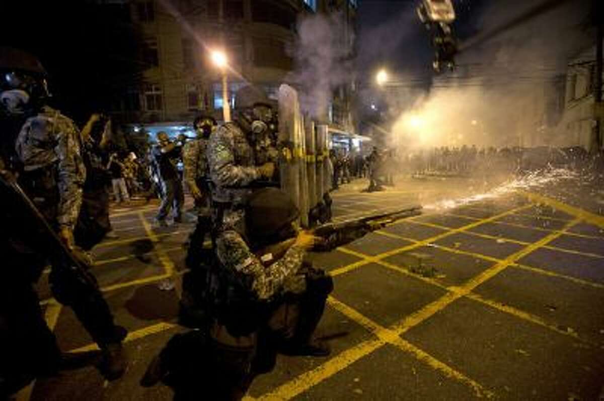 In this June 30, 2013 file photo, military police fire tear gas at protestors near Maracana stadium as Brazil and Spain play the final Confederations Cup soccer match in Rio de Janeiro, Brazil.