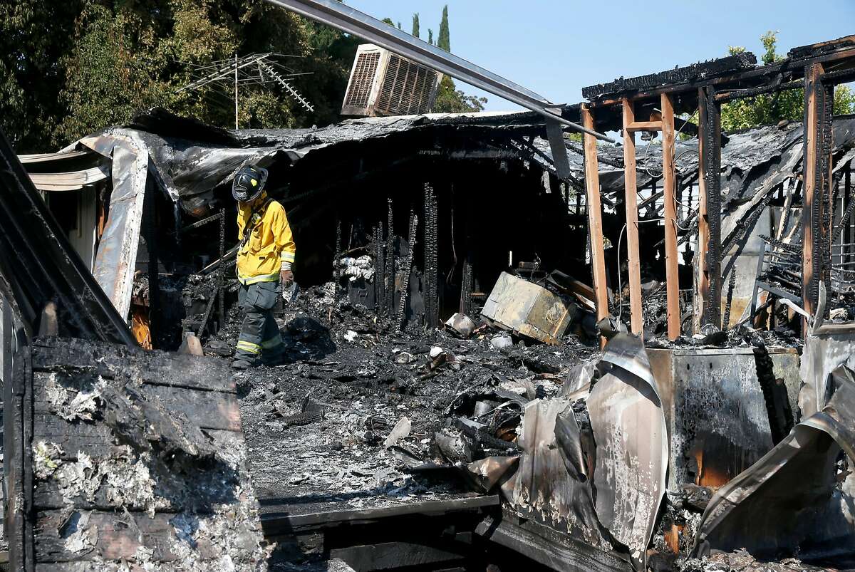A San Jose fire investigator walks through the charred remains of a deadly fire at the Golden Wheel Mobile Home Park in San Jose, Calif. on Wednesday, Aug. 16, 2017, one day after the blaze destroyed the home killing one adult and two young children inside.