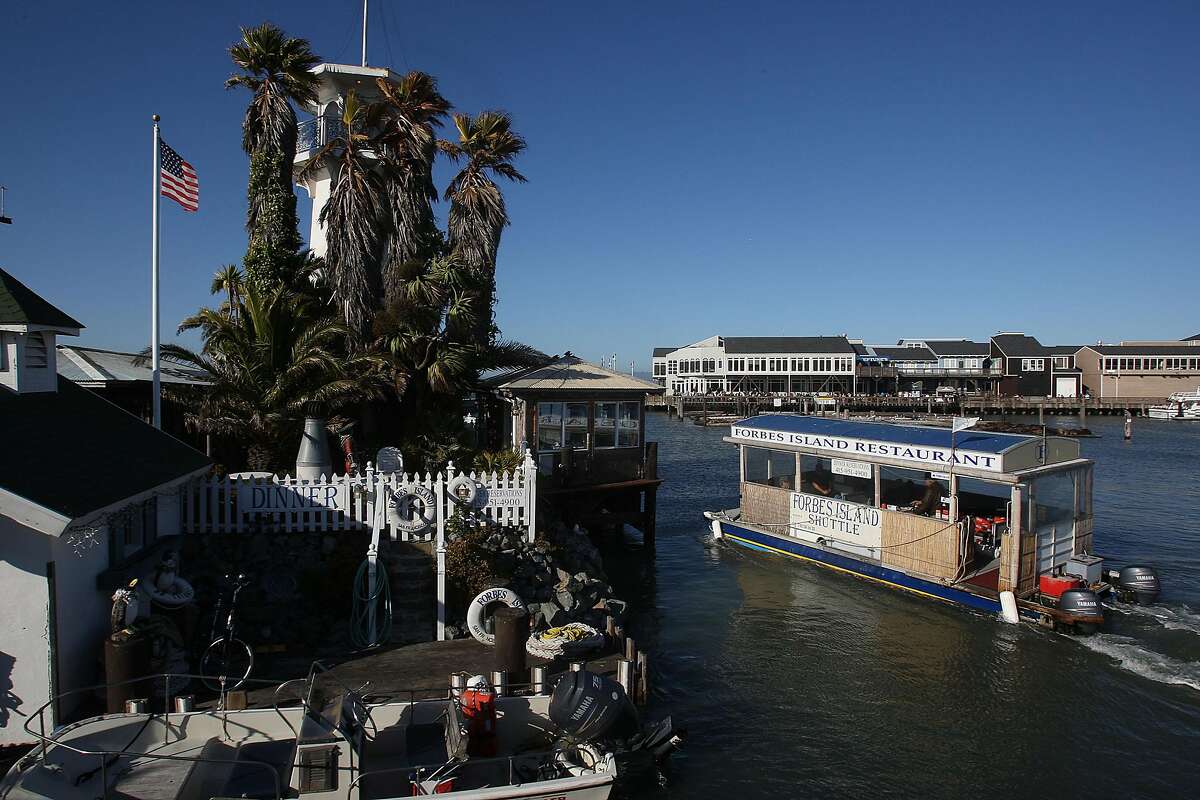 An overview of the floating restaurant, Forbes island, taken from Pier 41 looking towards Pier 39 in San Francisco, Calif., on Thursday, July 1, 2010. The motorboat (right) is driven by owner Mr.Forbes who picks up visitors from the dock and offers a mini tour.