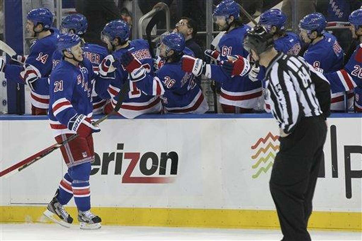New York Rangers' Derek Stepan (21) celebrates with his teammates after scoring a goal during the first period of the NHL hockey game against the New Jersey Devils, Saturday, April 27, 2013 at Madison Square Garden in New York. (AP Photo/Mary Altaffer)