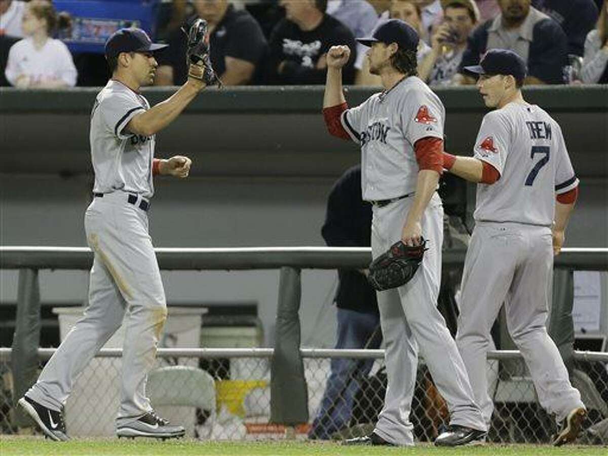 Boston Red Sox center fielder Jacoby Ellsbury, left, celebrates with starter Clay Buchholz, center, and shortstop Stephen Drew after catching a fly ball hit by Chicago White Sox's Alexei Ramirez during the fifth inning of a baseball game in Chicago, Wednesday, May 22, 2013. (AP Photo/Nam Y. Huh)