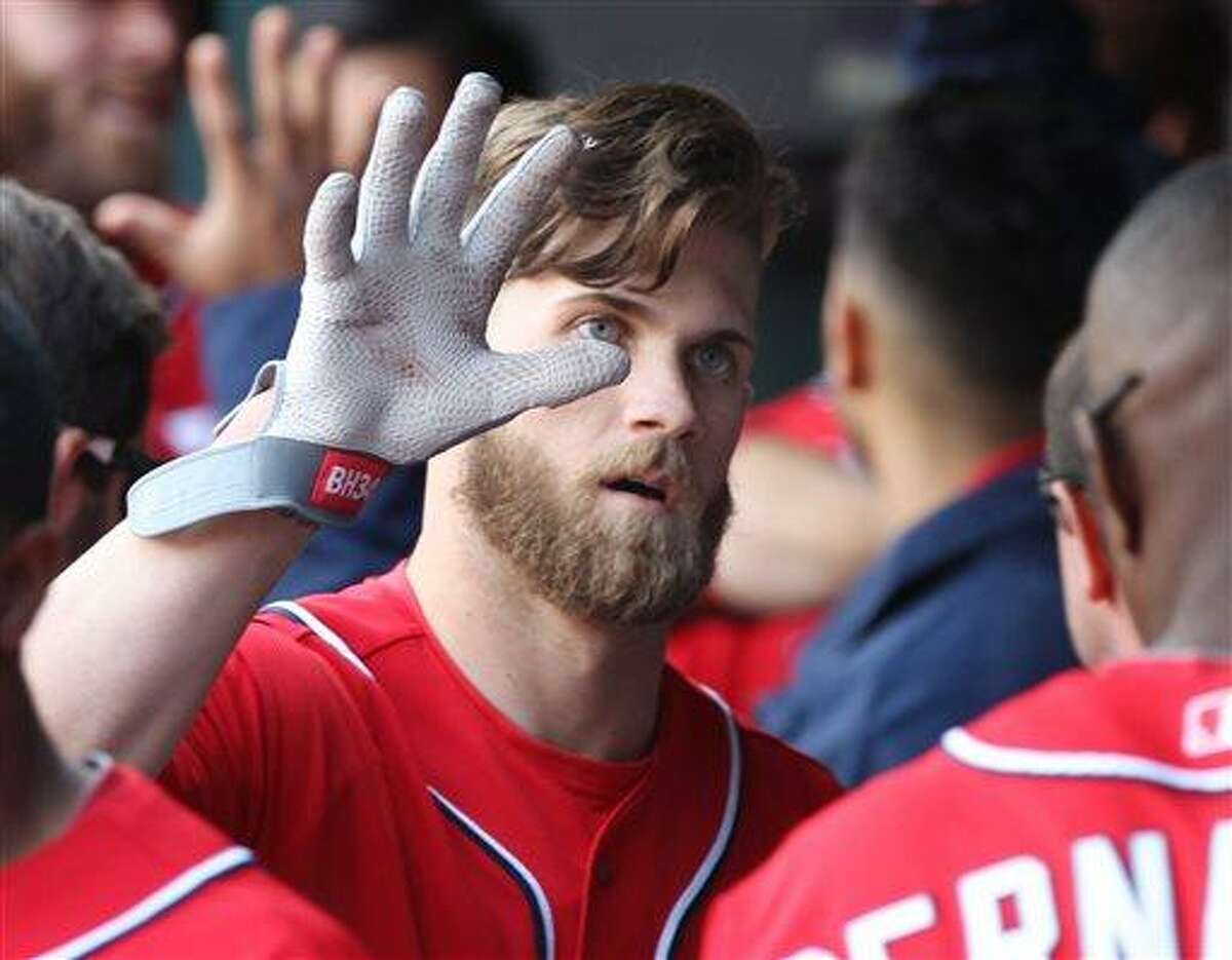 Washington Nationals' Bryce Harper celebrates with teammates after hitting a two-run home run in the third inning of a baseball game against the New York Mets in New York on Saturday, April 20, 2013. (AP Photo/Peter Morgan)