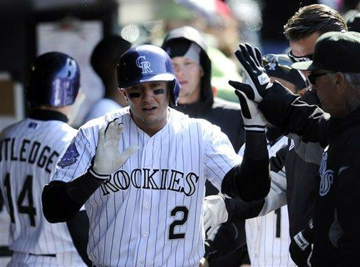 Colorado Rockies' Troy Tulowitzki celebrates a home run with teammates in the dugout during the eighth inning of a baseball game against the New York Mets on Thursday, April 18, 2013, in Denver. (AP Photo/Jack Dempsey)
