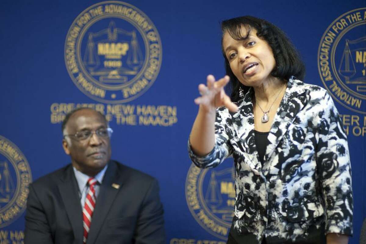 NAACP President James Rawlings looks on as Bridegette Russell, Managing Director of The Home Ownership Center makes a point about The Community Impact Mortage Program a joint program between First Niagra Bank and the NAACP at a press conference held at the NAACP's office at 545 Whalley Ave in New Haven April 16, 2013. vm Williams