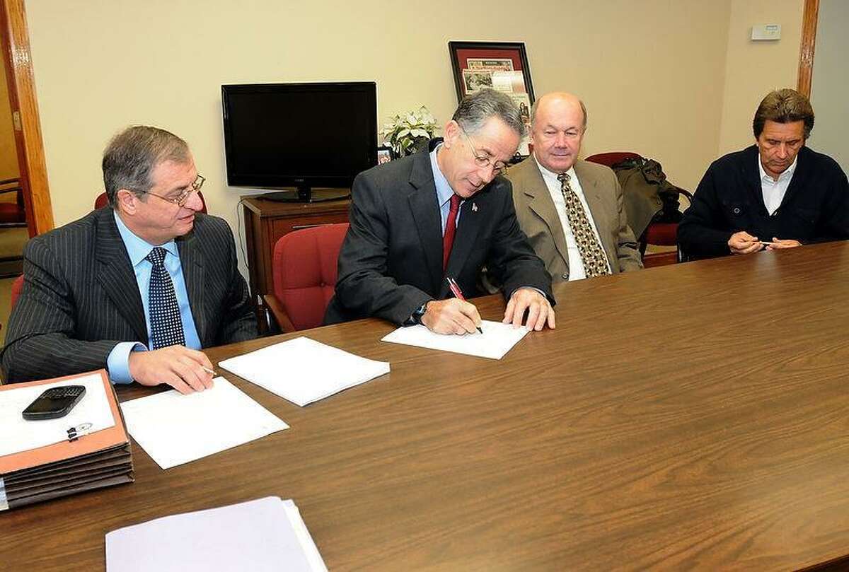 The Town of East Haven, its police and police commission sign a consent letter from the Department of Justice in Mayor Joe Maturo office Thursday, November 15, 2012, detailing an agreement to rebuilding the East Haven Police department. From left in photo are Attorney Larry Sgrignari, representing the Town of East Haven, Mayor Joe Maturo, East Haven Police Chief Brent Larrabee and East Haven Police Commission Chairman Joseph Civitello. The standards to be enforced include specific plans to create biased-free policing, monitor use of force, searches and seizure, guidance on policies and training, ways to handle and measure civilian complaints, plans for supervision and management and community engagement or oversight. Photo by Peter Hvizdak / New Haven Register