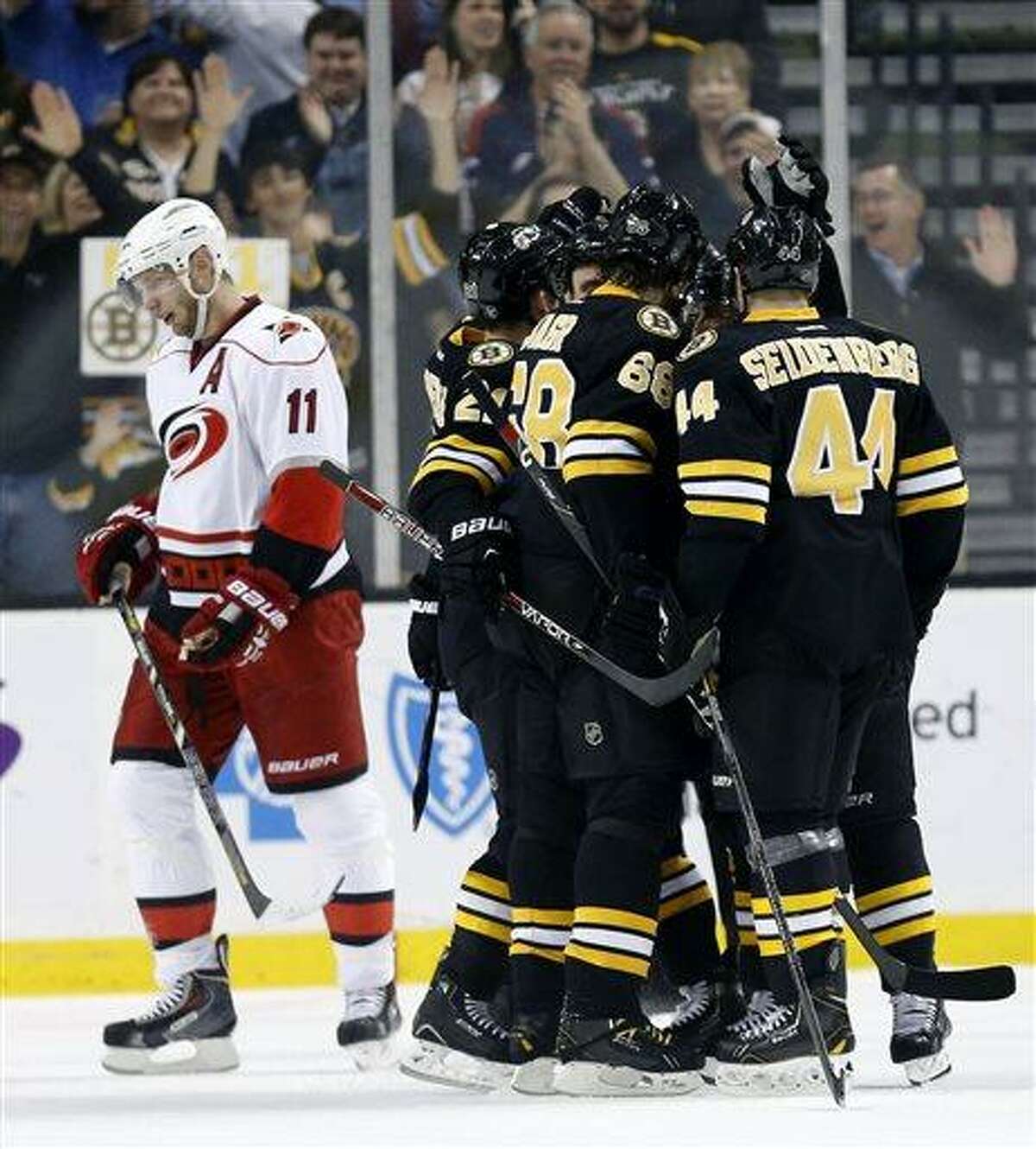 Boston Bruins' Dennis Seidenberg (44) and Jaromir Jagr (68) celebrate with teammates after Bruins' Brad Marchand scored his second goal as Carolina Hurricanes' Jordan Staal (11) skates away in the first period of an NHL hockey game in Boston, Monday, April, 8, 2013. (AP Photo/Michael Dwyer)