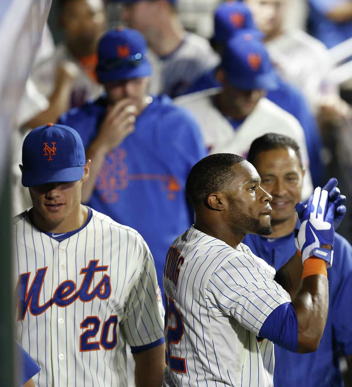 New York Mets left fielder Eric Young Jr., right, celebrates in the dugout after scoring a run in the eighth inning against the Colorado Rockies Tuesday. (AP Photo/John Minchillo).