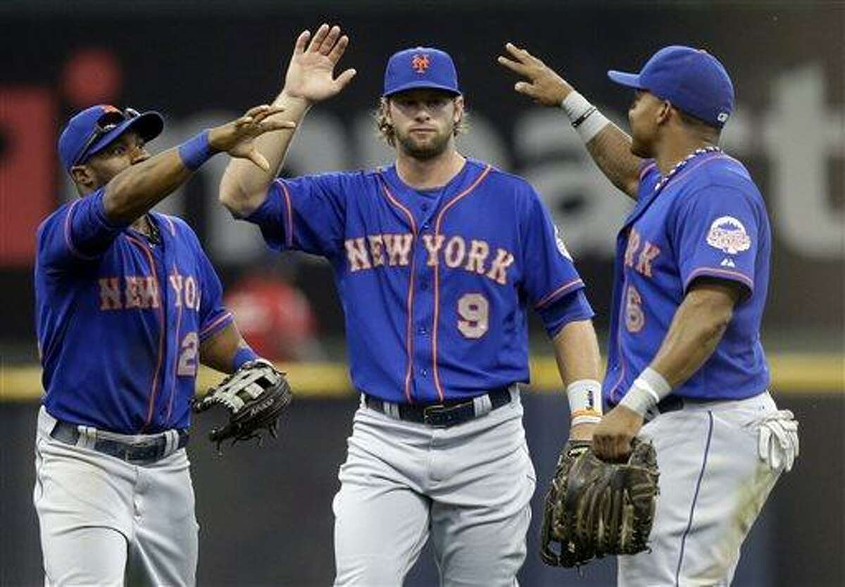 From left to right, New York Mets' Eric Young Jr., Kirk Nieuwenhuis and Marlon Byrd celebrate after a baseball game against the Milwaukee Brewers, Sunday, July 7, 2013, in Milwaukee. The Mets won 2-1. (AP Photo/Morry Gash)