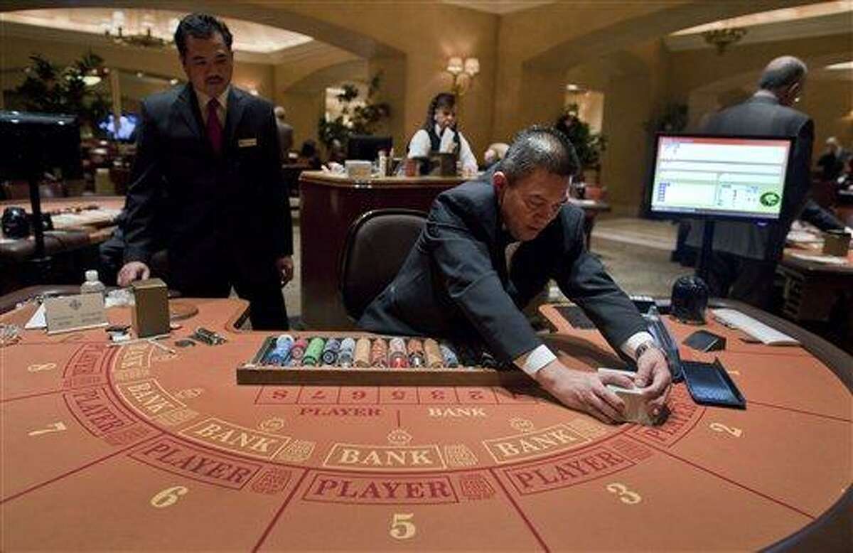 Baccarat dealer Ramiro Nepomuceno, right, shuffles cards as floor supervisor Sam Insyxiengmay looks on while preparing a table for play at the MGM Hotel and Casino Wednesday in Las Vegas. There are generally more Asian gamblers in Vegas because of the Chinese New Year, and it means increased traffic at high limit baccarat tables. Though not widely known, baccarat is actually the most profitable table game for casinos, which try to court Asian gamblers who tie luck and good fortune to the start of the Lunar Year. Associated Press