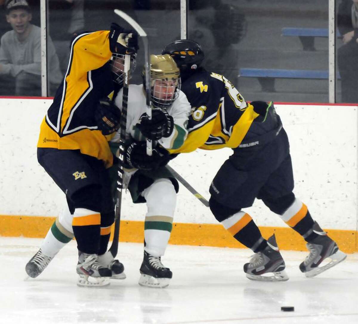 East Haven against Notre Dame of West Haven at Bennett Rink boys hockey. NotreDame-West Haven's Eric Austin squeezes between East Haven players. Photo by Mara Lavitt/New Haven Register