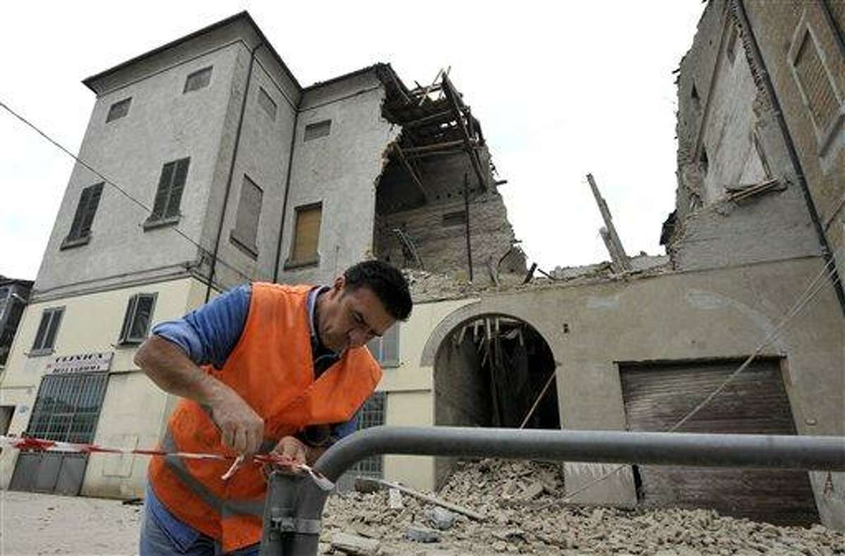 A volunteer ropes off the area surrounding a collapsed building in Finale Emilia, northern Italy after a quake hit northern Italy early Sunday. Associated Press