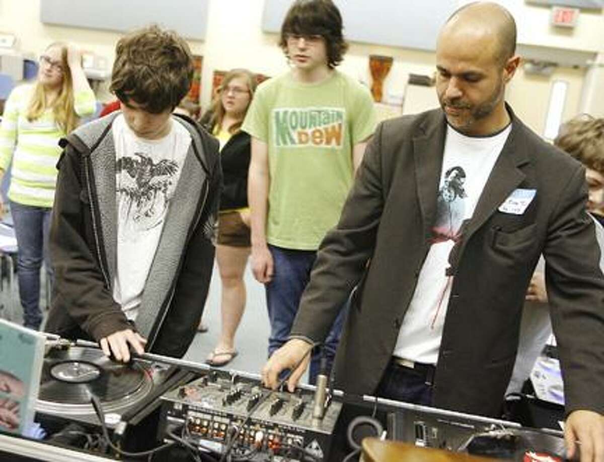Photo by JOHN HAEGER Otto Shortell Middle School seventh-grader Tyler Coapman, 12, checks out DJ Marc Tucci's turntable during a career fair held at the school on Tuesday, May 17, 2011.