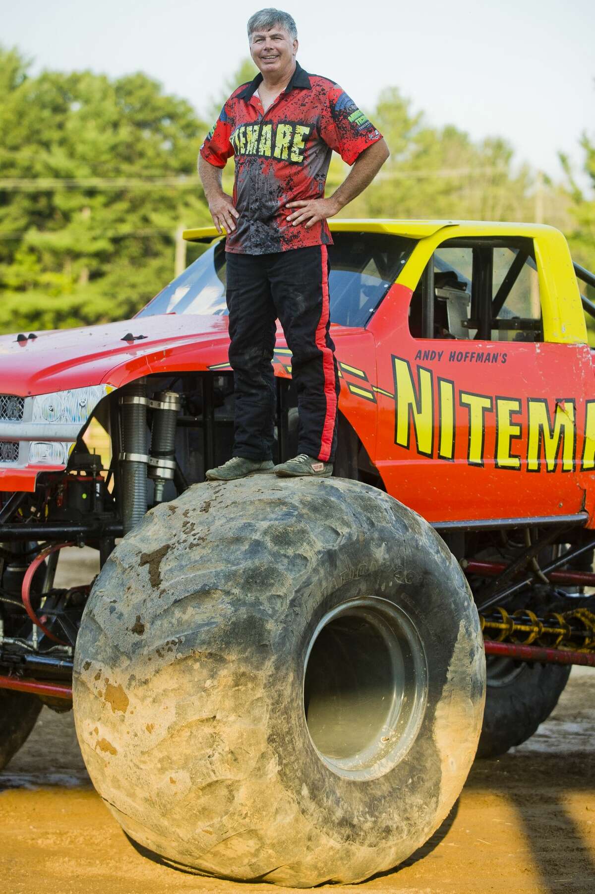 Andy Hoffman of Indiana stands on top of a tire on his monster truck, called Nitemare, before participating in a monster truck rally on Wednesday, August 16, 2017 at the Midland County Fairgrounds.