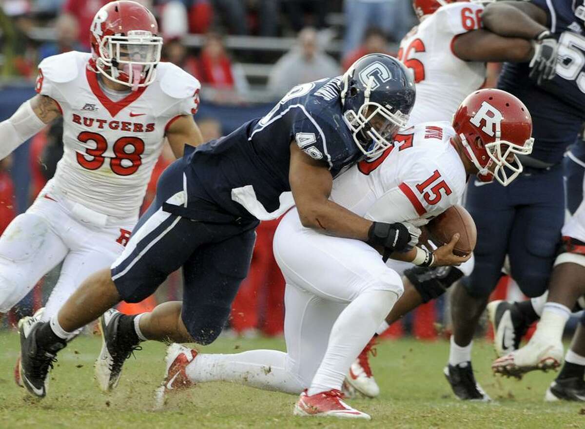 Connecticut's Trevardo Williams, left, sacks Rutgers quarterback Gary Nova during the second half of Connecticut's 40-22 victory in an NCAA college football game in East Hartford, Conn., on Saturday, Nov. 26, 2011. (AP Photo/Fred Beckham)