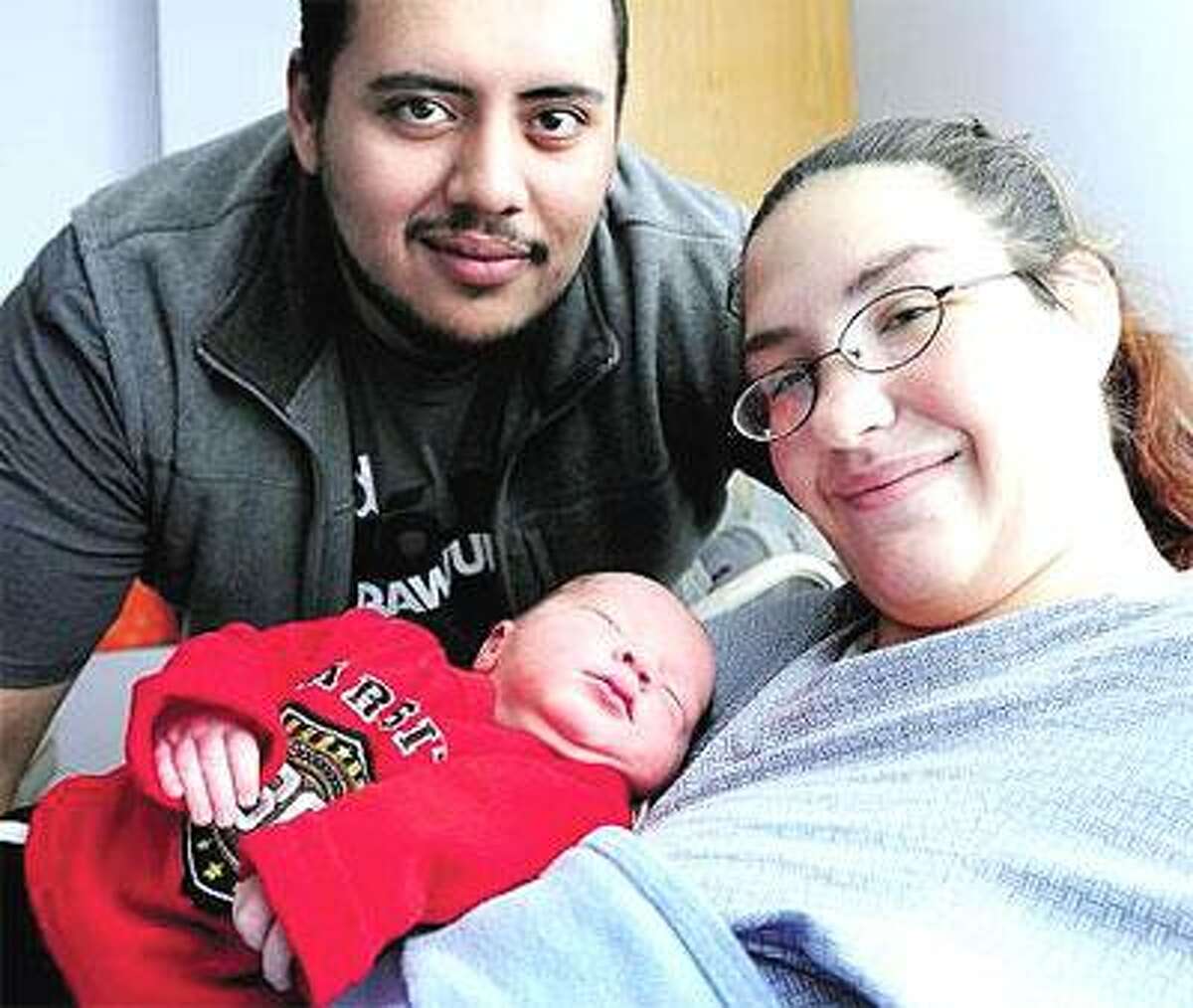 Emanuel Velez, top, and Heather Lafogg show off their newborn son, Angel Velez, who was born at 2:03 a.m. Saturday at the Hospital of Saint Raphael in New Haven. (Arnold Gold/Register)