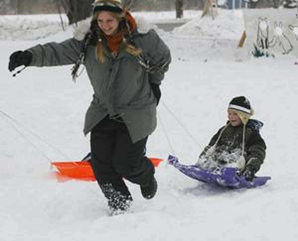 Photo by JOHN HAEGER Eli Albro, 5, holds onto the sled as he is pulled by his mother Tiffany White during a sled race at the Great Swamp's annual Winter Hibernation Festival on Saturday, Feb. 26, 2011. Albro and White are from Sherrill.