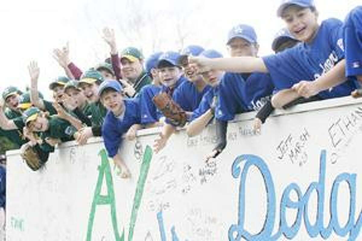 Photo by JOHN HAEGER Canastota Little League Major League members wave and cheer during the parade to open the 60th season of Little League in Canastota on Saturday, April 30, 2011.