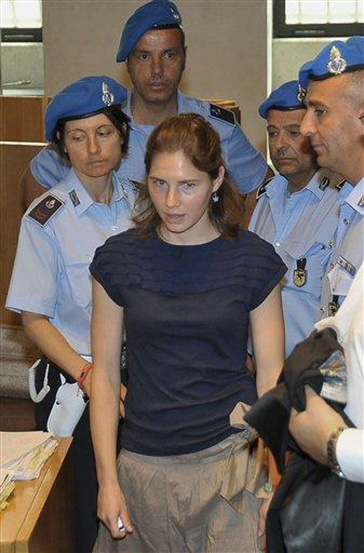 Amanda Knox, centre, escorted by Penitentiary guards, arrives for the appeal hearing, in Perugia, Italy, Monday, June 27, 2011. The appeals trial of American student Amanda Knox against her murder conviction resumed Monday in a packed courtroom where an Ivorian man convicted in the slaying is to take the stand in closely watched testimony. Rudy Hermann Guede is serving a 16-year-prison sentence for the 2007 murder of Meredith Kercher, a British student who was stabbed to death in the apartment she shared with Knox. (AP Photo/Stefano Medici)