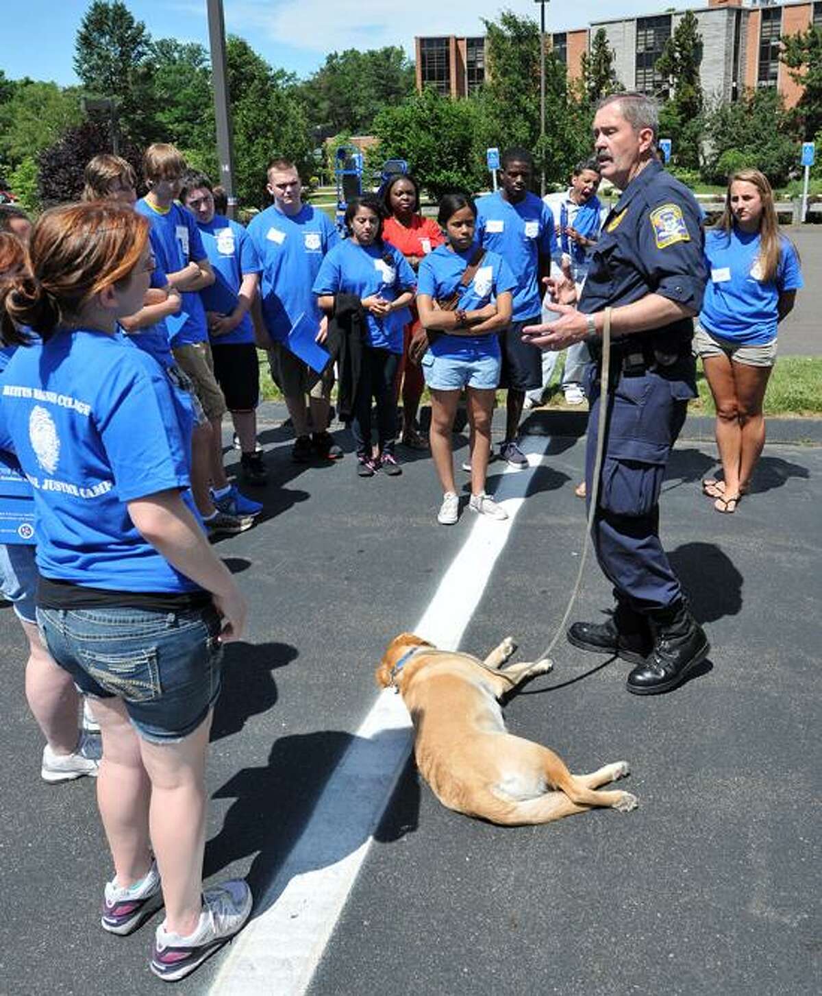 Detective Ken Christiansen, with "Ritz," an accelerant detection K9 of the state police Fire Marshal's office, talks to youths at the Criminal Justice Camp held at Albertus Magnus College. Peter Casolino/New Haven Register
