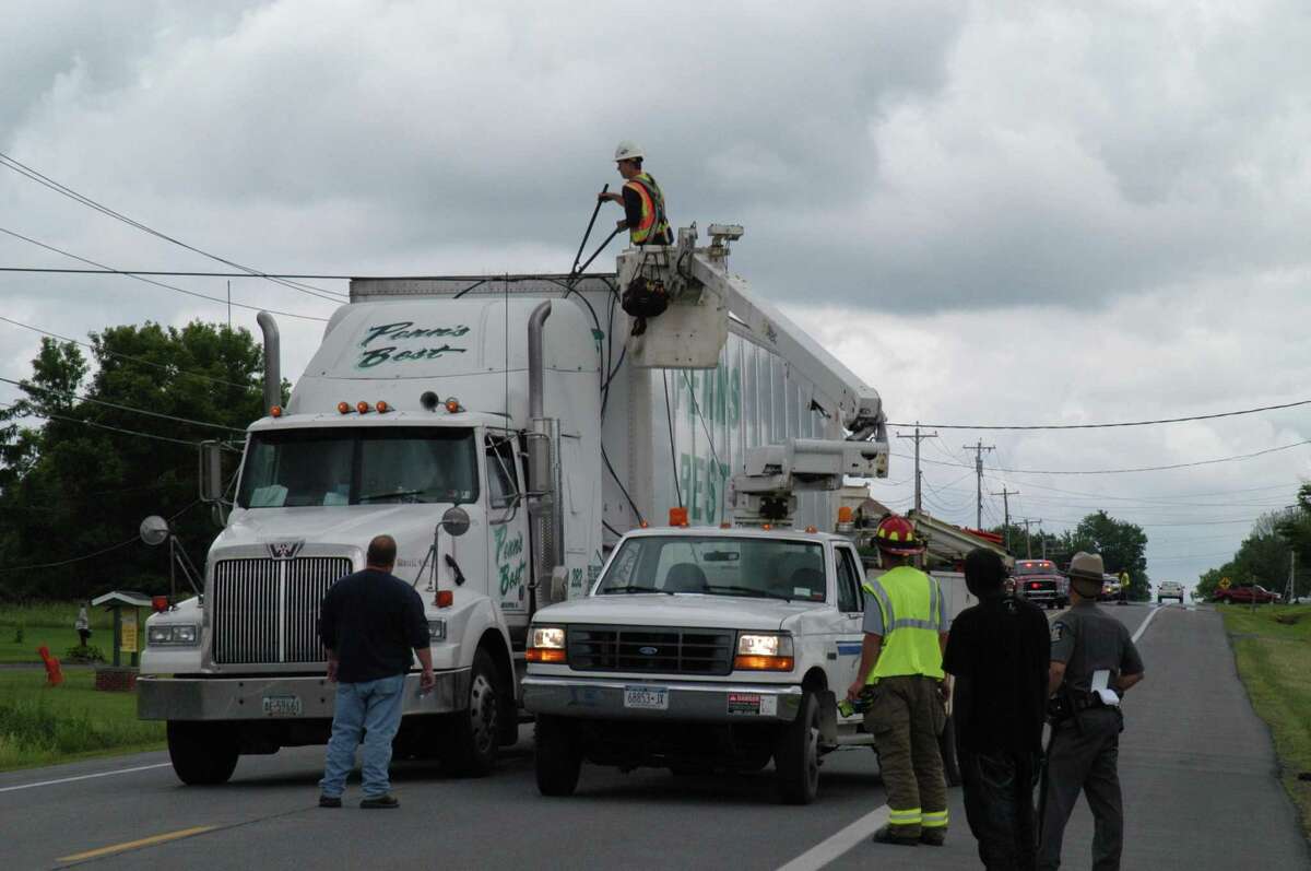 Dispatch Photo by Caitlin Traynor TDS Telecom workers cut away a telephone wire entangled with a tractor trailer on Route 31 in Verona Monday around 11:45 a.m.