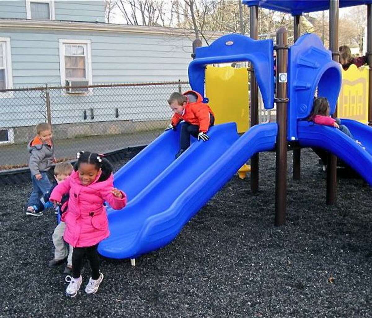 Jaelyne Dure, 4, of Derby, is all smiles as she gets off a slide on the new playscape at St. Mary-St. Michael School in Derby. She is joined by Maksim Godbolt, 4,, of Derby, standing left rear, and Cooper Wherley, 5, of Ansonia on the slide. Patricia Villers/Register