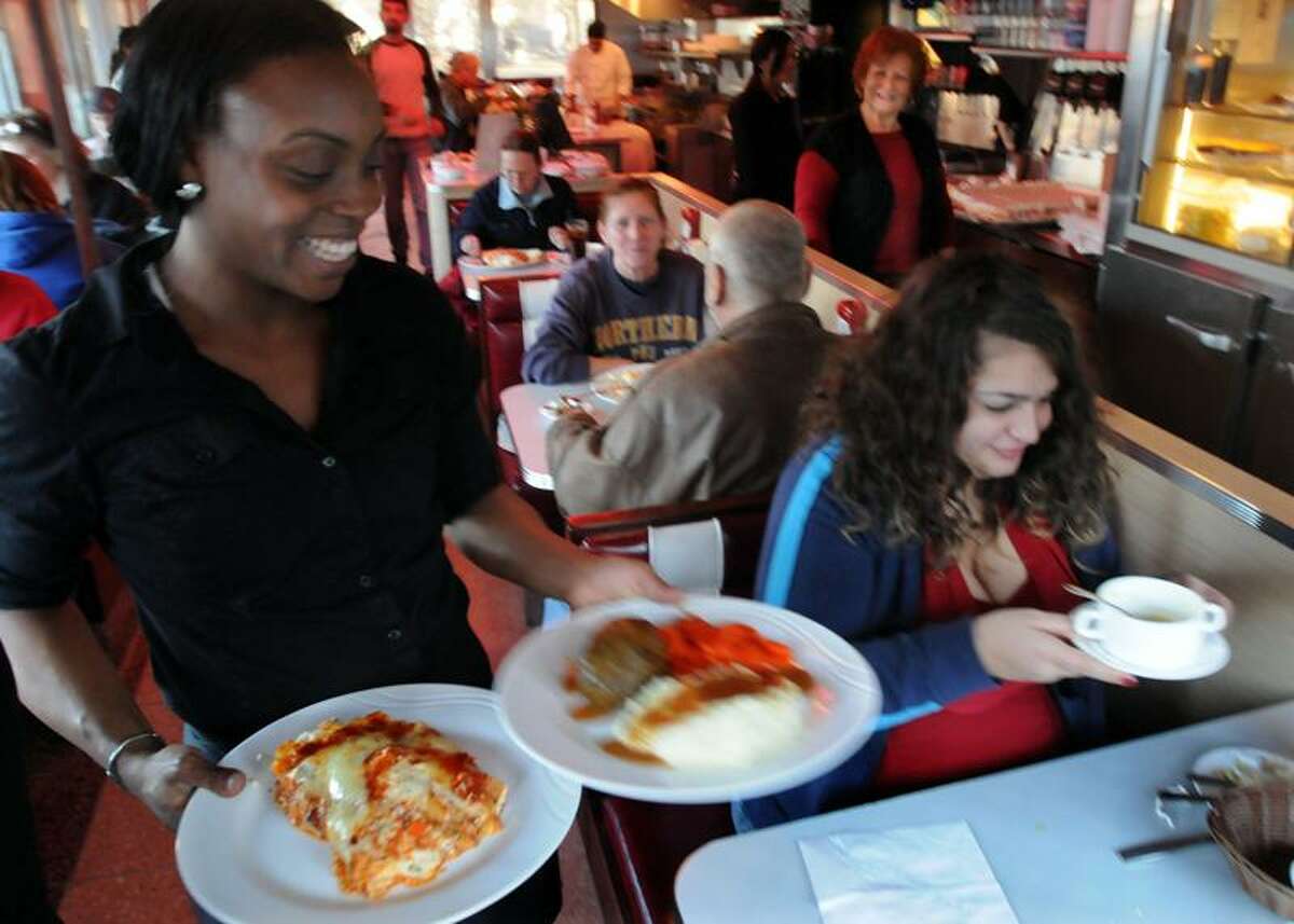 Georgie's Diner in West Haven served free dinners to customers between 3 and 6 p.m. Christmas Eve. Waitress Lena Bell of West Haven serves Jennifer Miskowizcz of Derby and a companion. Photo by Mara Lavitt/New Haven Register