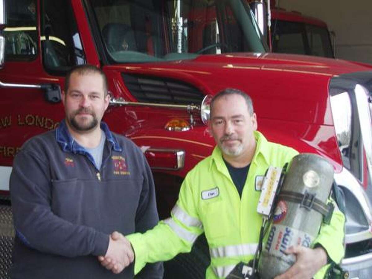 SUBMITTED PHOTO From left is Chief Tim Dodge from the Verona Fire Department and Chief Danny Hartzog from the New London Fire Department. Hartzog is holding one of the newly donated air packs.