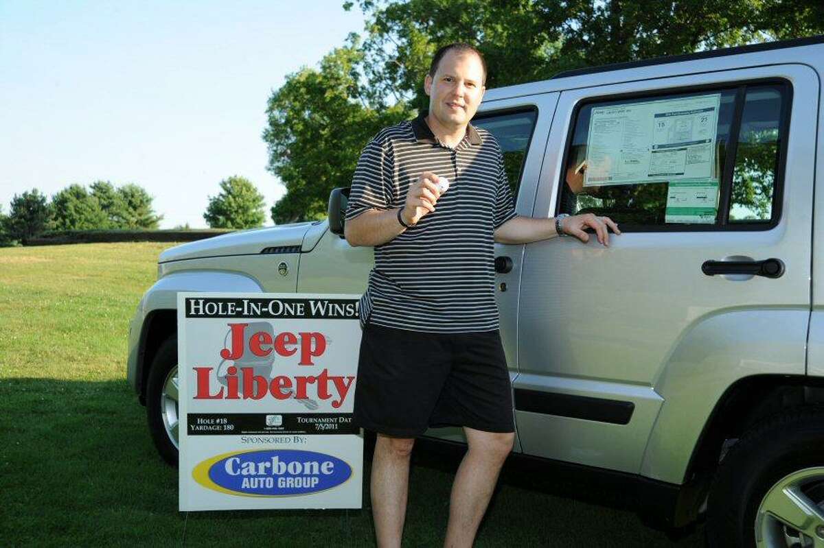 Submitted Photo Dave Faccioli of Utica shows off the car he won after a hole-in-one at the Boilermaker golf tournament.