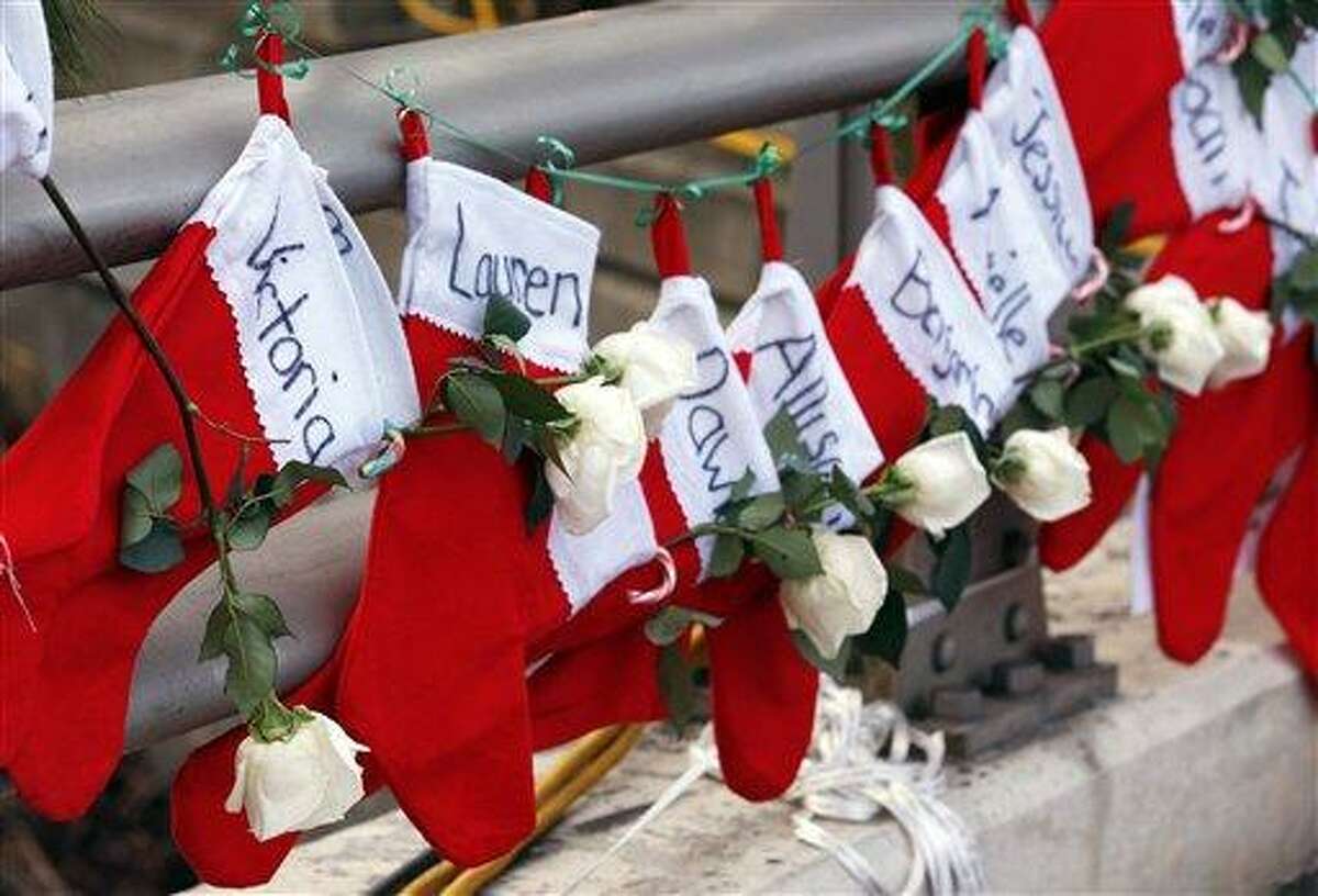 Christmas stockings with the names of shooting victims hang from railing near a makeshift memorial near the town Christmas tree in the Sandy Hook section of Newtown. The grieving town is trying to find meaning in Christmas. AP Photo/Julio Cortez