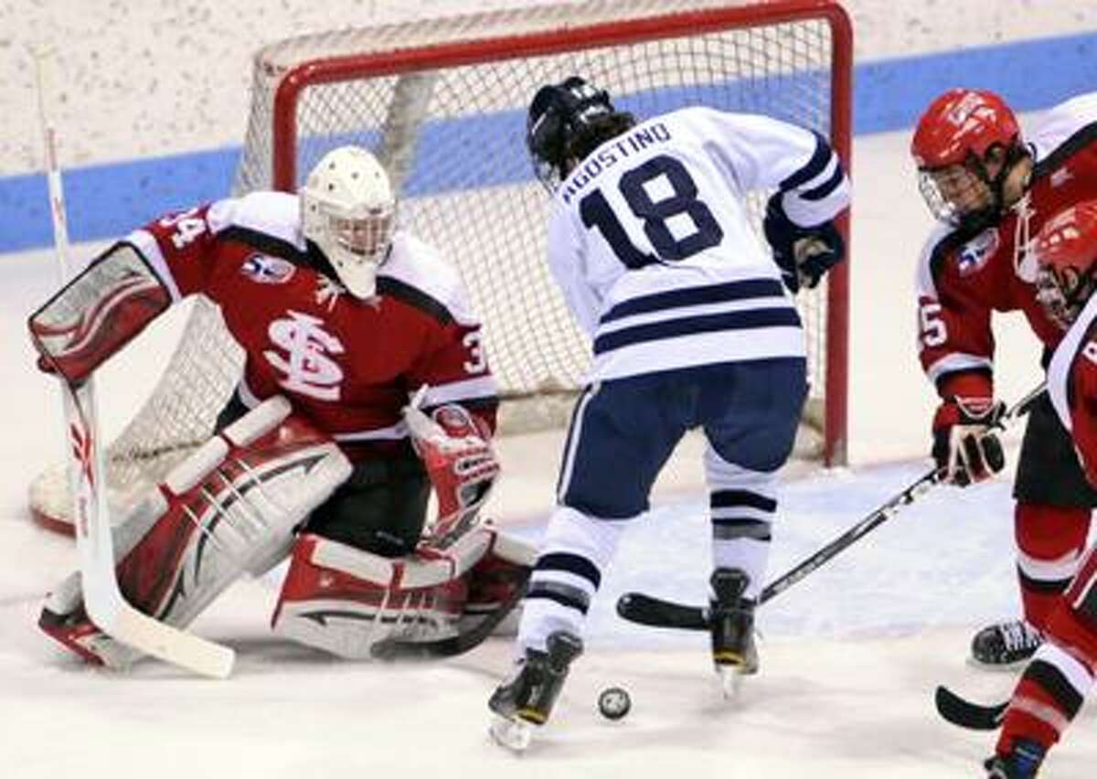 Kenny Agostino of Yale University #18, has the puck hit off his skate and was the assist for a goal by Yale teammate Chris Cahill (not in photo) after St. Lawrence University goalie Matt Weninger makes the save during the first period of the last game of the best of 3 games of ECAC hockey tournament quarter-final action Sunday night 3/13/11 at Yale's Ingalls Rink in New Haven. Photo by Peter Hvizdak / New Haven Register March 13, 2011 ph2272 Connecticut