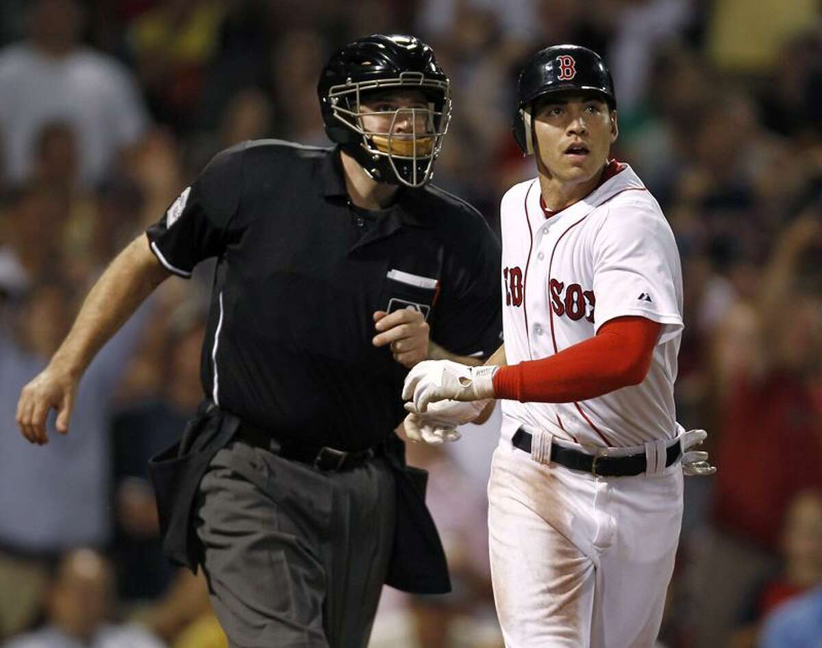 Boston Red Sox's Jacoby Ellsbury is bumped by home plate umpire Bill Welke as they look to see if a ball hit by Ellsbury was fair, during the sixth inning of a baseball game against the Baltimore Orioles at Fenway Park in Boston on Thursday, July 7, 2011. The ball stayed fair for a home run. (AP Photo/Winslow Townson)