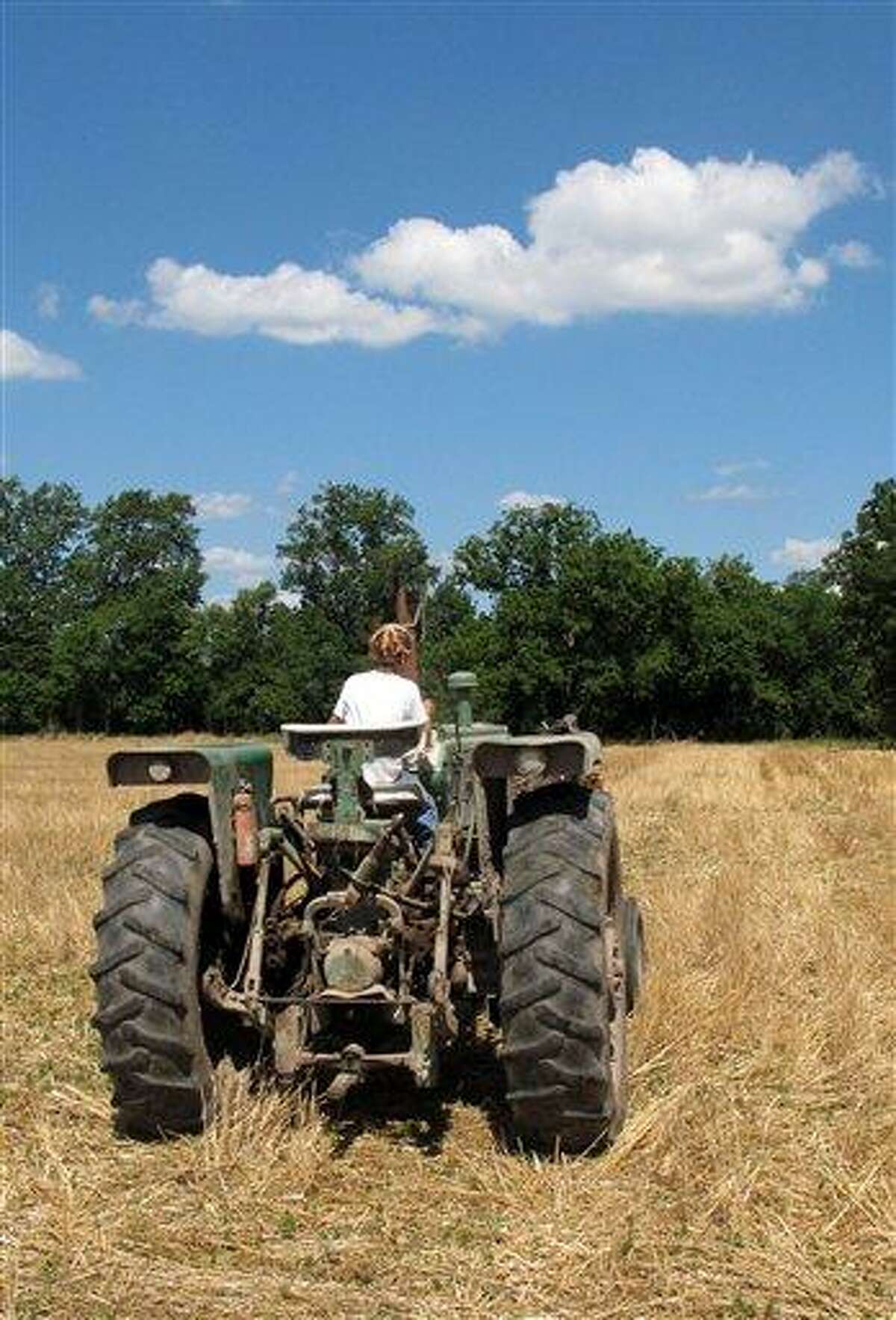 Jacob guides a tractor through a bean field June 20 on his grandparents' property near Fults, Ill. Associated Press