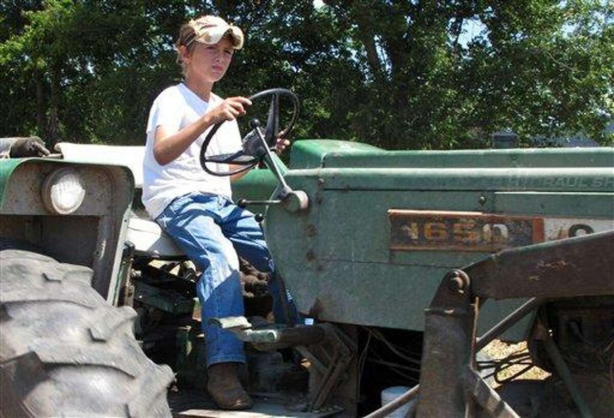 Jacob Mosbacher, 10, guides a tractor through a bean field June 20 on his grandparents' property near Fults, Ill. Agriculture organizations and federal lawmakers from farm states succeeded last spring in convincing the U.S. Labor Department to drop proposals limiting farm work by children such as Jacob, whose parents say such questions of safety involving kids should be left to parents. Associated Press