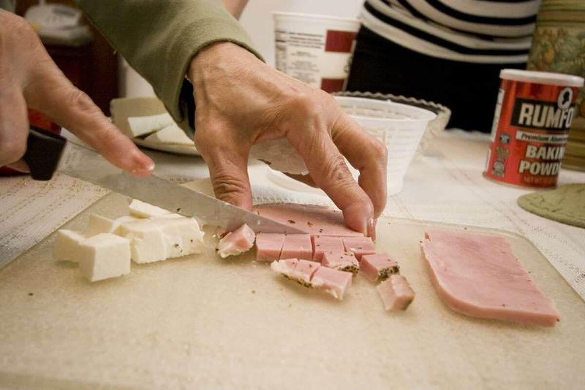 Argento cuts the ham and cheese for the pizzagaina into the right size dice.