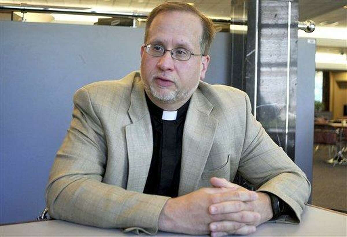Roman Catholic priest, the Rev. James Manship, speaks during an interview June 7 in Hartford. Manship who was arrested in 2009 after he filmed two East Haven police officers' harsh treatment of Hispanics, has been named a public citizen of the year from the state chapter of the National Association of Social Workers, for acting with courage and leadership to help a vulnerable population. (AP Photo/Journal Inquirer, Leslloyd F. Alleyne)