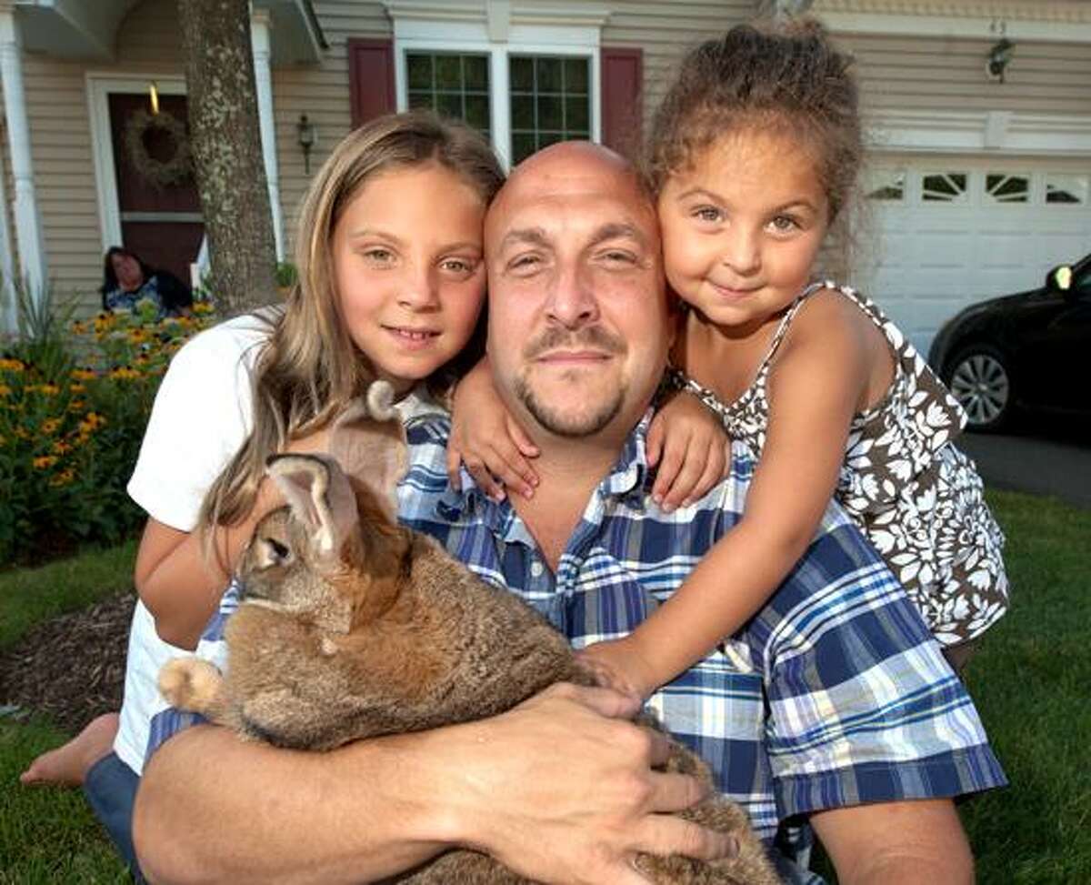 Kayden, her father, Josh, and her sister, Madison Lydsky, pose with Sandy the bunny. VM Williams/Register