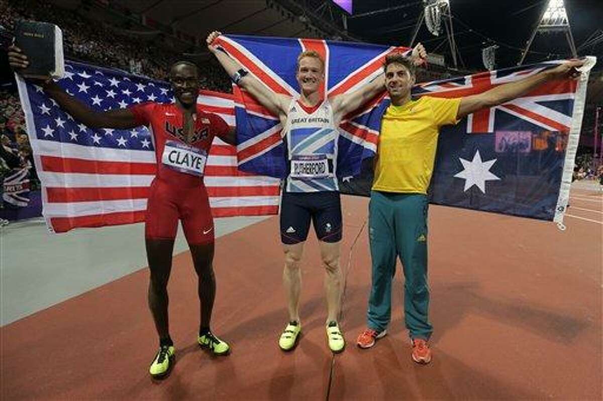 Britain's gold medal winner Greg Rutherford is flanked by Australia's silver medalist Mitchell Watt, right, and United States' bronze medalist Will Claye after the men's long jump during athletics competition in the Olympic Stadium at the 2012 Summer Olympics, Saturday, Aug. 4, 2012, in London. (AP Photo/David J. Phillip )