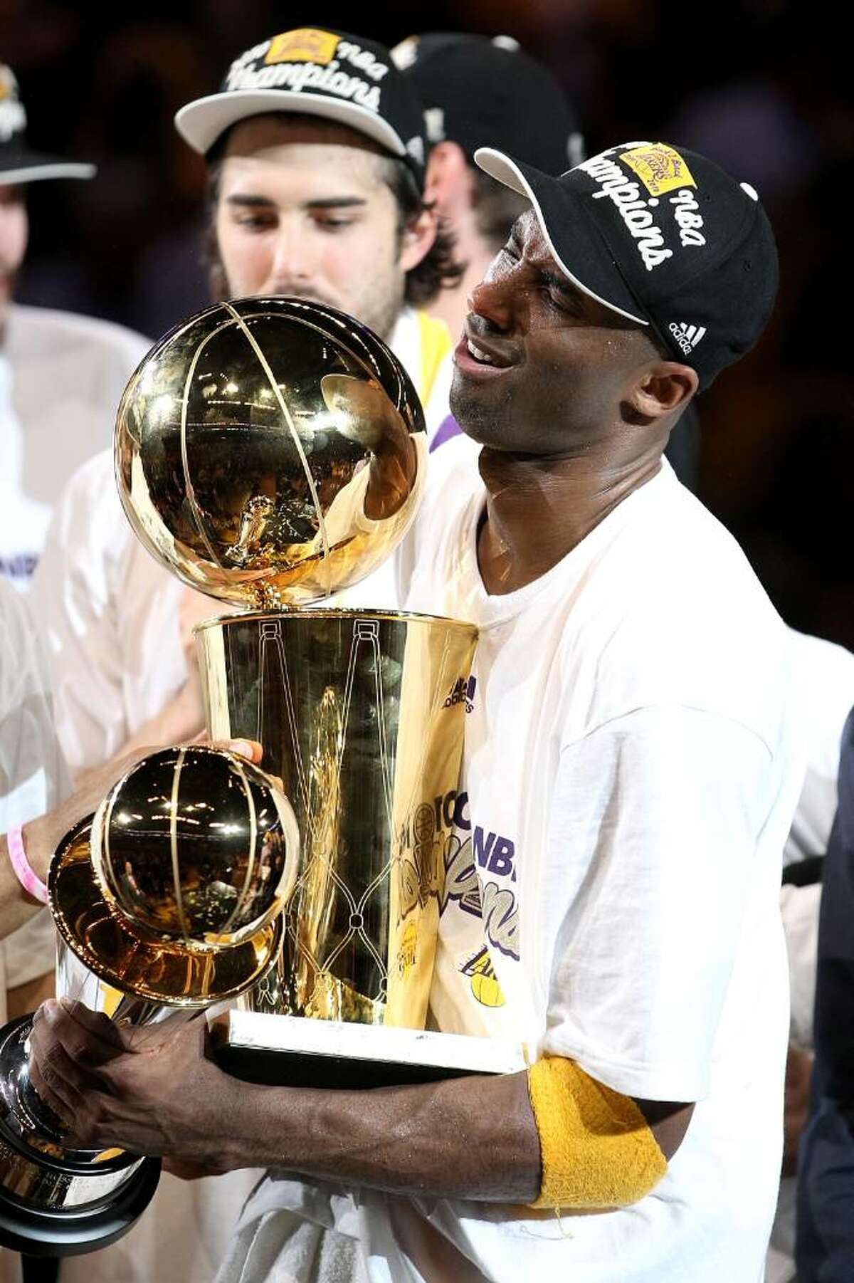 Kobe Bryant holds both the Lakers 2010 NBA Championship trophy and the 2010  NBA Finals trophy.