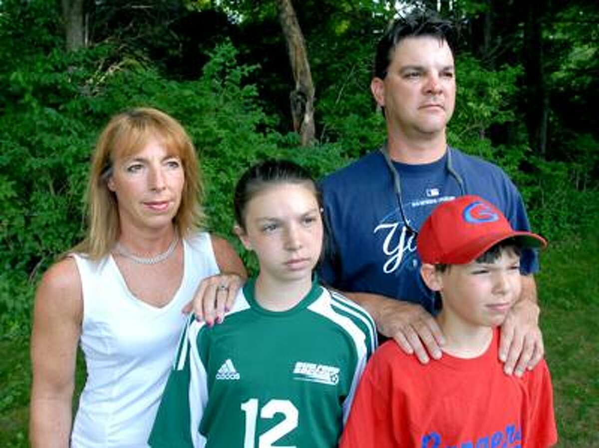 Pam Gery, left, is photographed with her husband, Donovan Edwards, and their children, Gleeson, center, and Chance, right, at Bittner Park in Guilford Wednesday evening. Arnold Gold/Register
