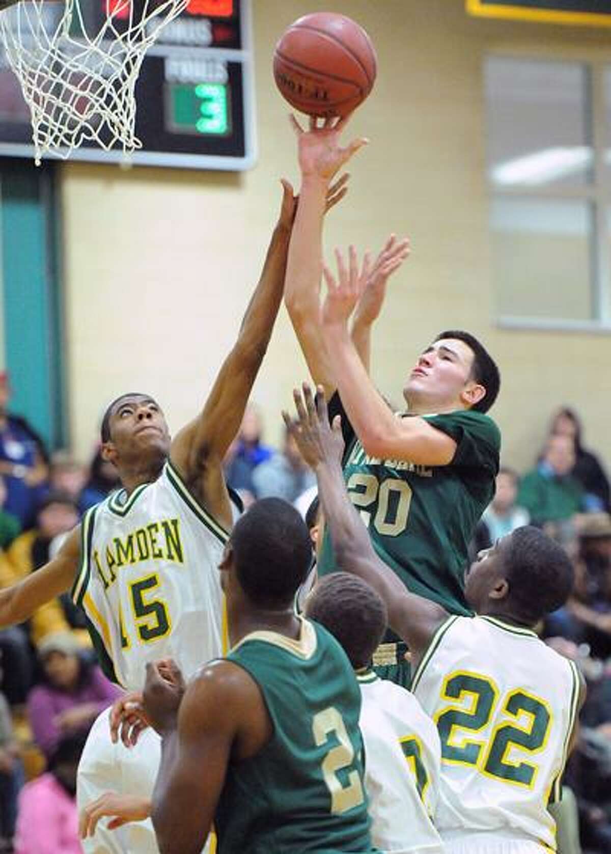 Hamden--Notre Dame's Tom Doyle puts up a shot as Hamden's Reggie Mayo defends during the first half. Photo by Peter Casolino/New Haven Register12/23/10 Cas101223