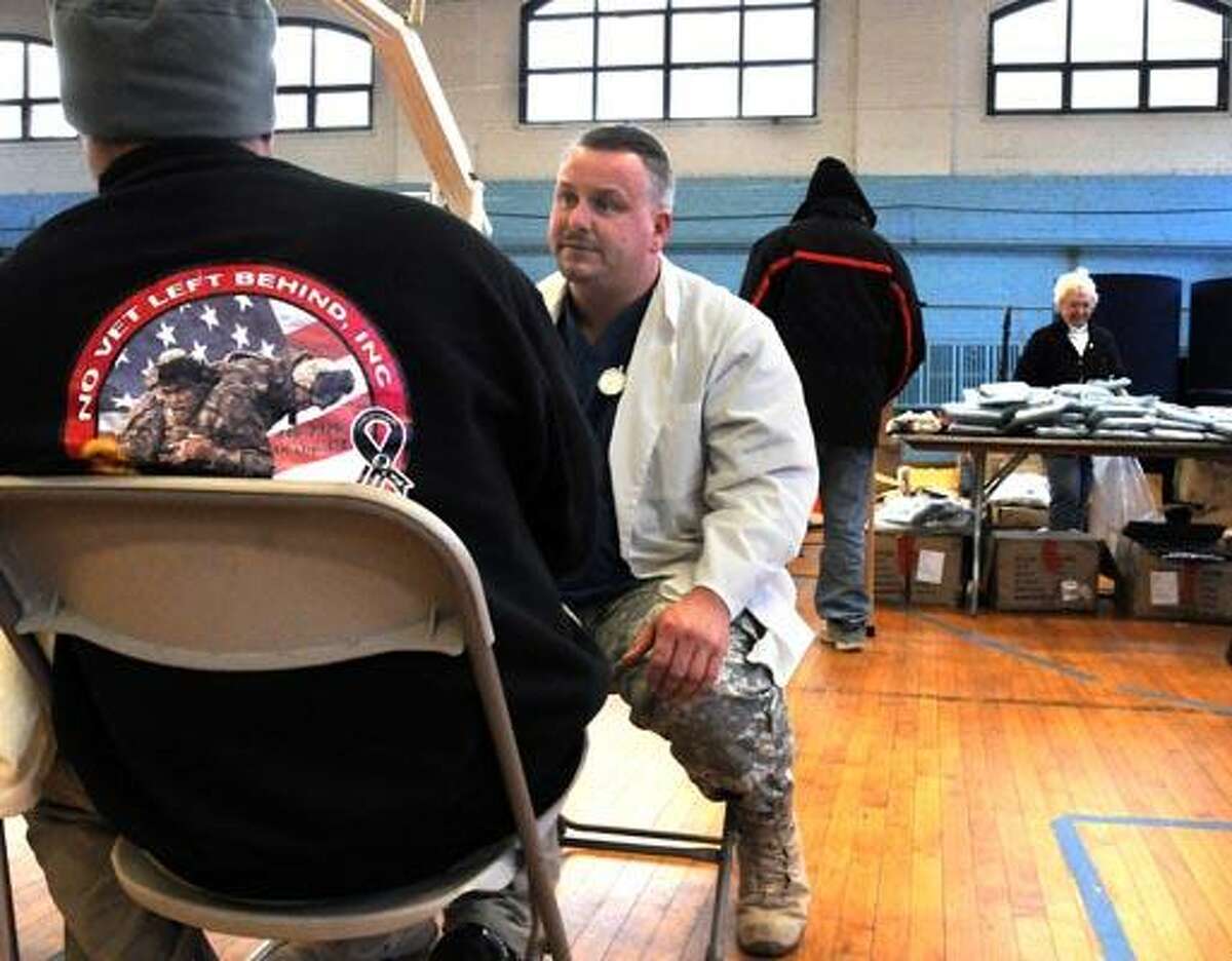 A No Vet Left Behind event was held at the Ansonia Armory. Free clothing, health care and even hair cuts were offered to veterans. Here Iraq and Aghanistan veteran James Yeomans of West Haven left talks with Gregory Coyle, RNPhD of Ansonia, the medical officer for No Vet Left Behind. Photo by Mara Lavitt/New Haven Register12/10/10