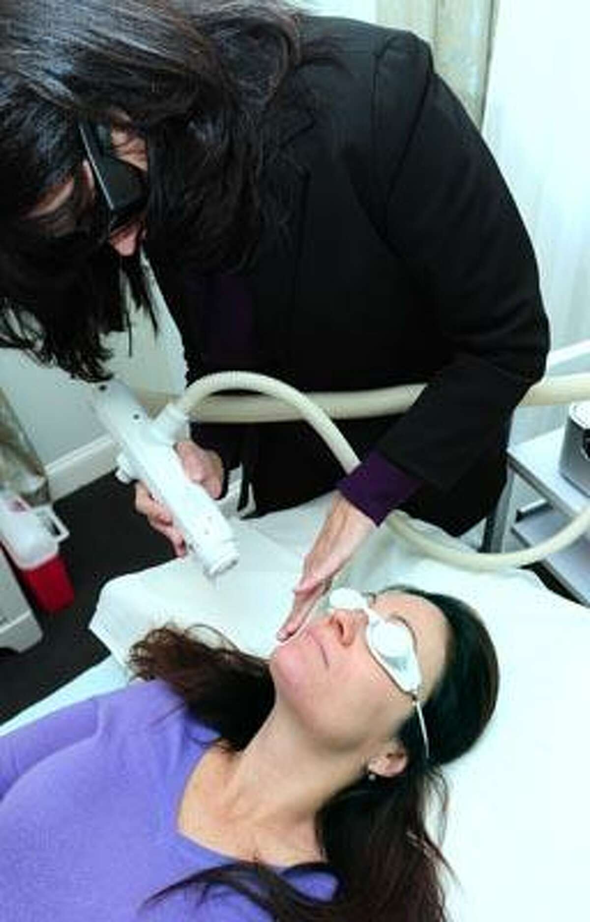 Dr. Susan O'Malley (top) performs a laser treatment on Clare Dube of Madison at the Sonas Med Spa in Madison on 12/9/2010.Photo by Arnold Gold/New Haven Register AG0395D