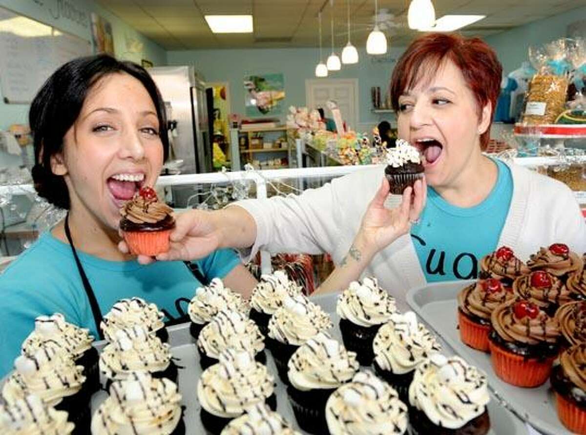 Bakers Brenda DePonte, left, Carol Vollono, daughter and mother co-owners of the bakery Sugar in East Haven with some of their cupcakes made famous after winning the first round of season two in the Food Network's show "Cupcake Wars." (Photo by Peter Hvizdak/New Haven Register)