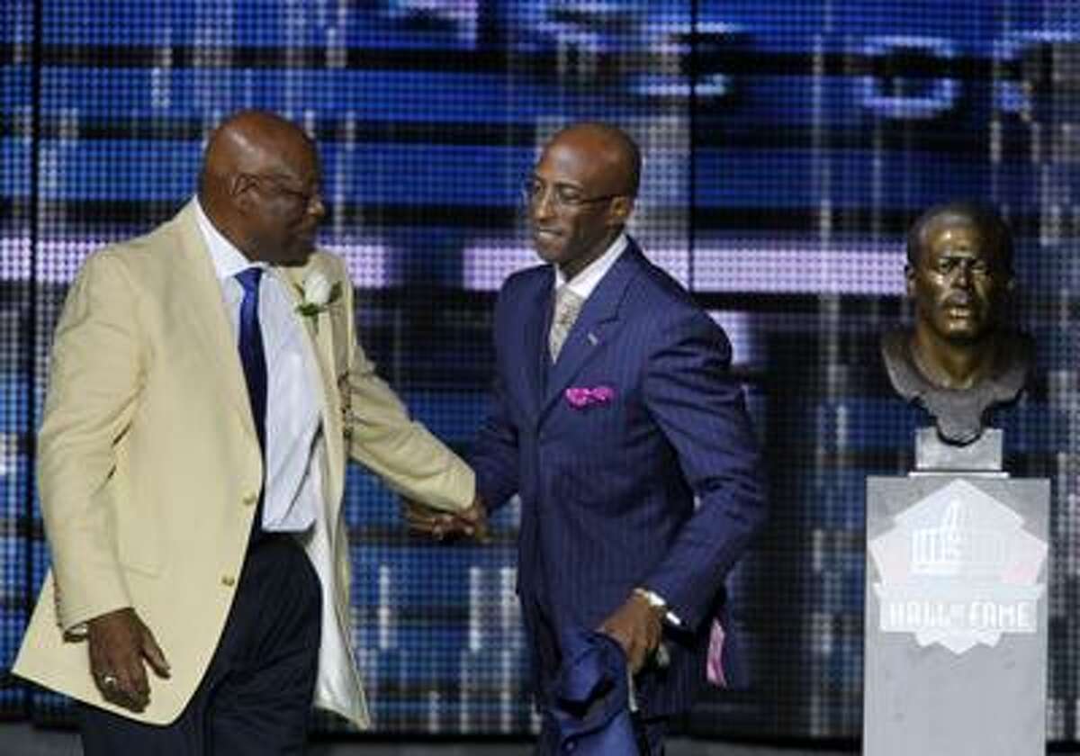 Former Hillhouse High and Denver Broncos running back Floyd Little, left, walks with his son, Marc, during Floyd's enshrinement in the Pro Football Hall of Fame Saturday in Canton, Ohio. (Associated Press/Ron Schwane)