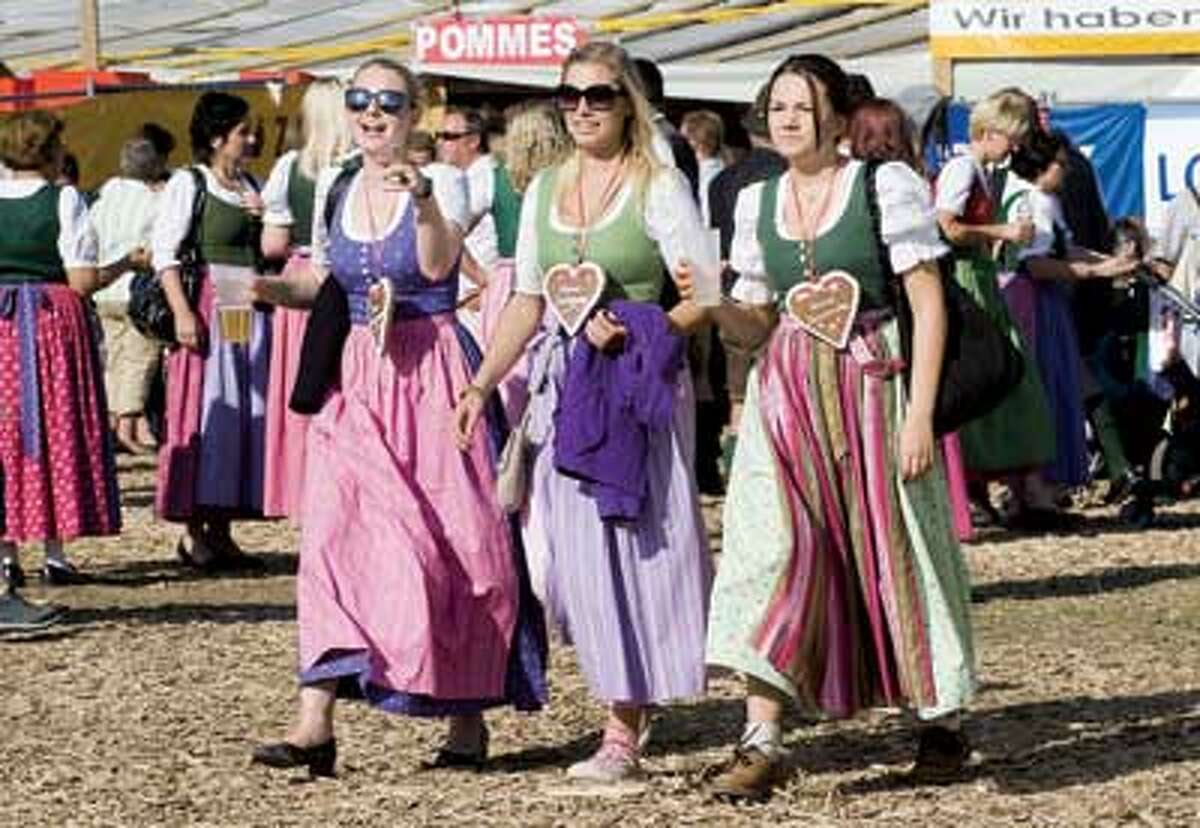 Young women arrive in their traditional dirndl dresses during a beer fest in Altaussee. (AP Photo)