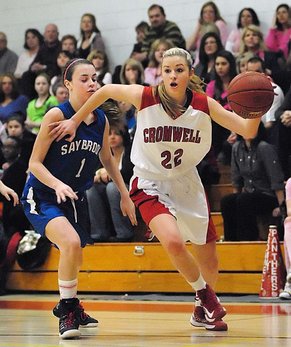 Catherine Avalone/The Middletown PressCromwell's Araya Lessard dribbles past Old Saybrook's Molly Beck during Friday nights game in Cromwell. Cromwell defeated Old Saybrook 51-40.