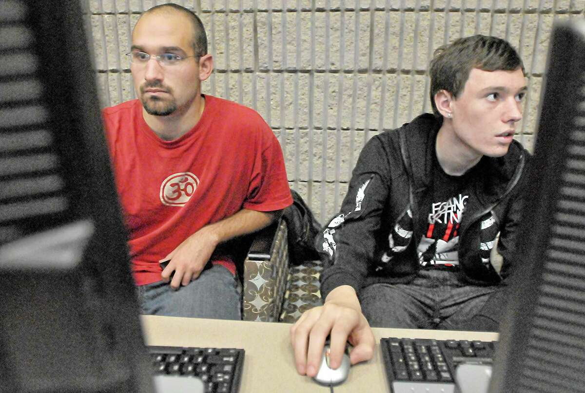 Members of the Middlesex Community College Computer Club Nathan Breininger, a Management Information Systems major from Durham, at left and Ethan Damuck, a Computer Science major East Haddam install drivers to desktop computers which the club will donate to the Ryan Woods Autism Foundation after-school program in Middletown. Catherine Avalone - The Middletown Press