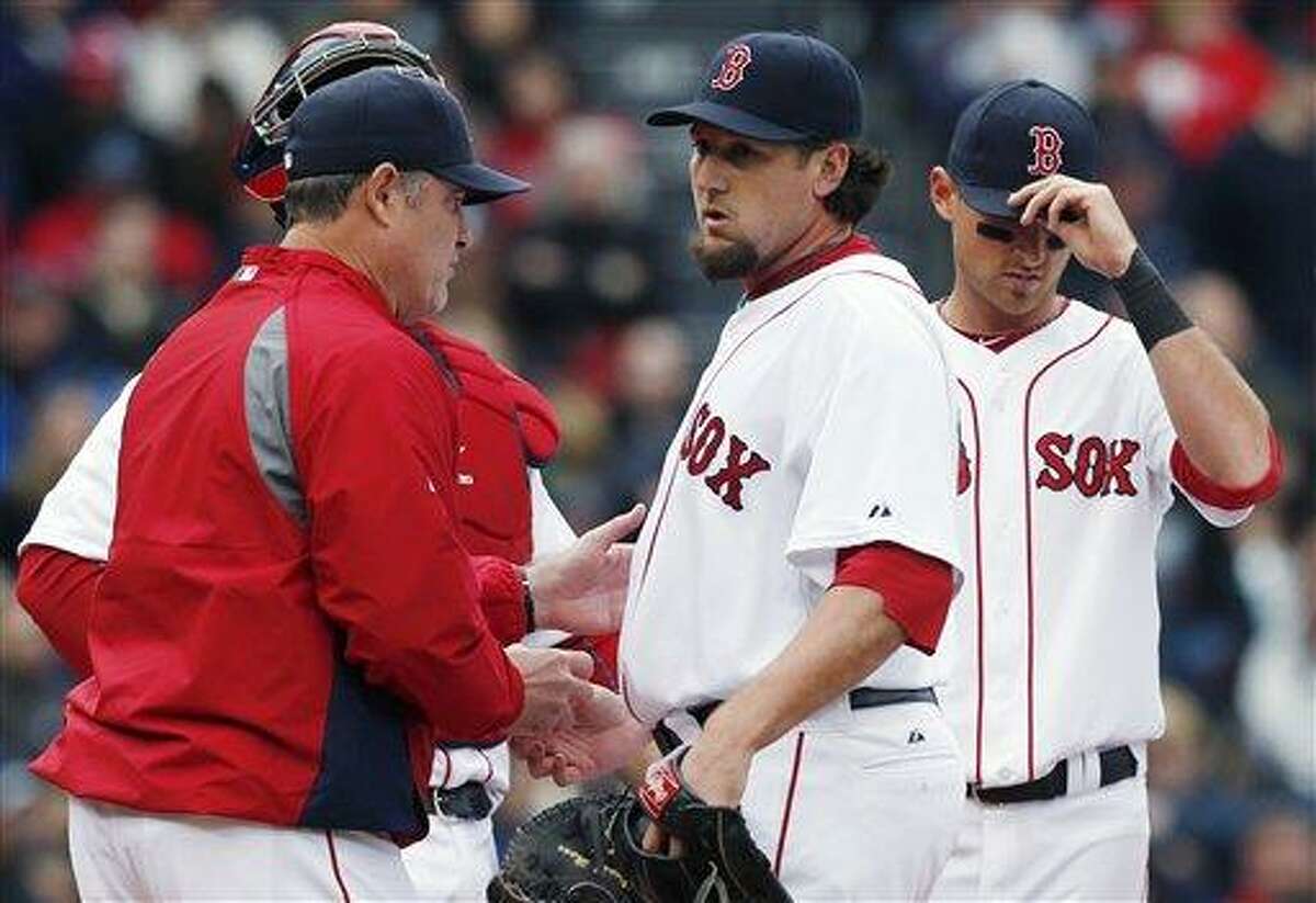 Boston Red Sox manager John Farrell, left, takes the ball from Joel Hanrahan, center, after Hanrahan put two men on base in the ninth inning of a baseball game against the Tampa Bay Rays in Boston, Saturday, April 13, 2013. (AP Photo/Michael Dwyer)