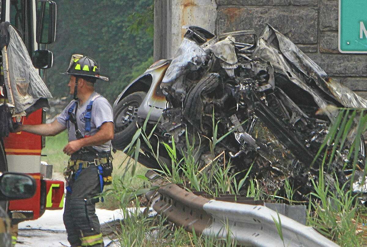 Emergency personnel work at the scene of a multi-fatal accident on the northbound Sprain Brook Parkway in Greenbugh, N.Y. on Sunday, Sept. 1, 2013. Police said the car hit the Underhill Road Bridge and burst into flames killing all four occupants early Sunday morning. (AP Photo/The Journal News, Frank Becerra Jr.)